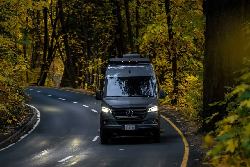 Furgoneta camper durante un viaje por carretera en un entorno de montaña.